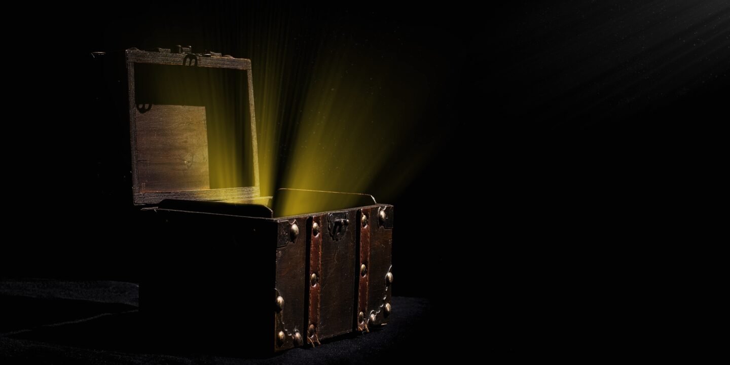 Person opening a mystery box filled with assorted collectibles, gadgets, and surprise items on a table.