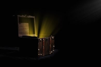 Person opening a mystery box filled with assorted collectibles, gadgets, and surprise items on a table.