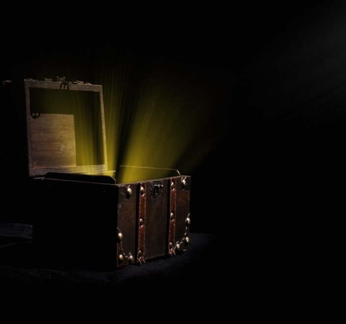 Person opening a mystery box filled with assorted collectibles, gadgets, and surprise items on a table.