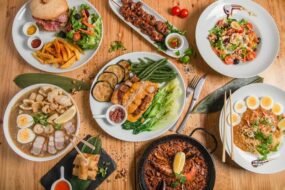 Traditional Filipino food spread featuring adobo, sinigang, lechon, lumpia, pancit, and halo-halo served on a dining table.
