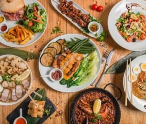 Traditional Filipino food spread featuring adobo, sinigang, lechon, lumpia, pancit, and halo-halo served on a dining table.