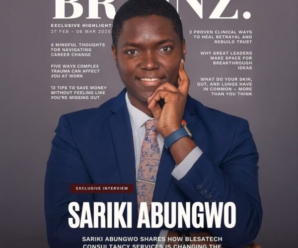 Professional reading Brainz Magazine articles on a laptop while working in a modern office