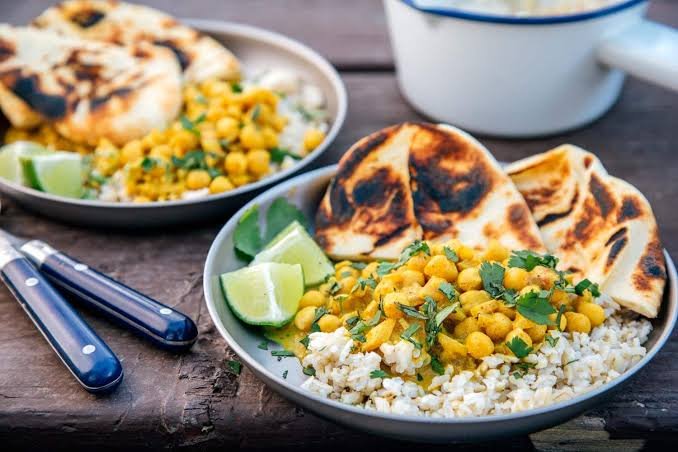 Camping dinner ideas including foil packet meals, burgers, chili, tacos, and Dutch oven cooking around a campfire.