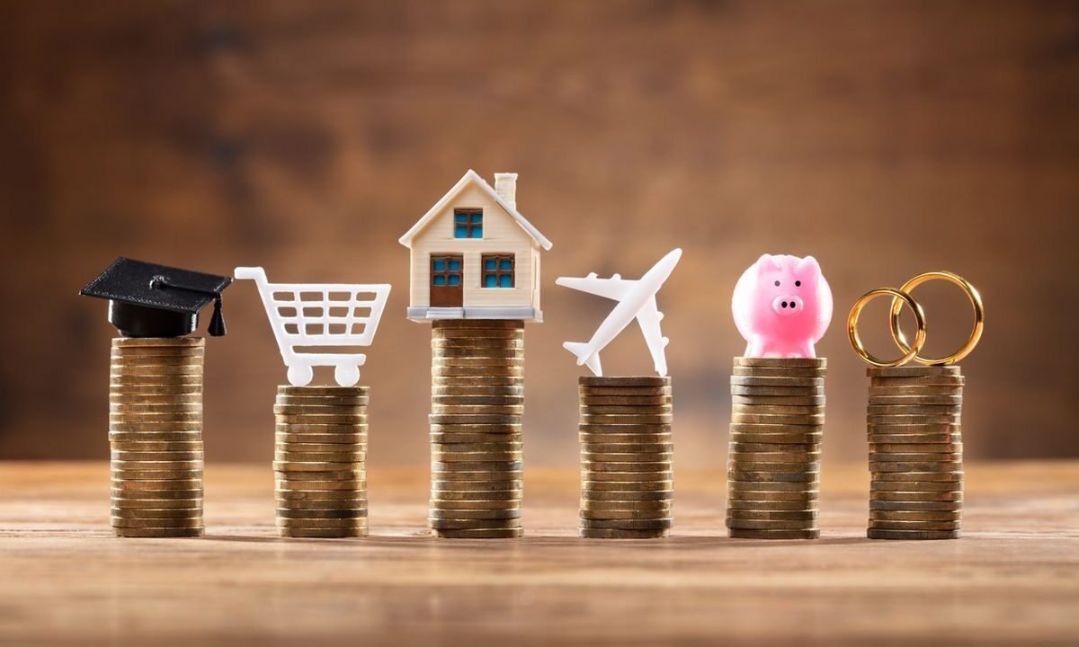 Person reviewing a household budget with calculator, notebook, and savings jar to improve personal finances using practical saving advice.