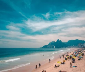 People enjoying Sundays in Rio with families relaxing on Ipanema Beach, cyclists along the waterfront, and a vibrant local market in Rio de Janeiro.