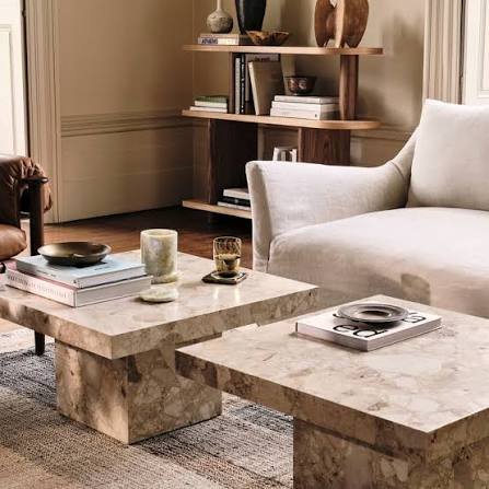 Modern coffee table decor with books, candles, greenery, and a decorative tray in a stylish living room