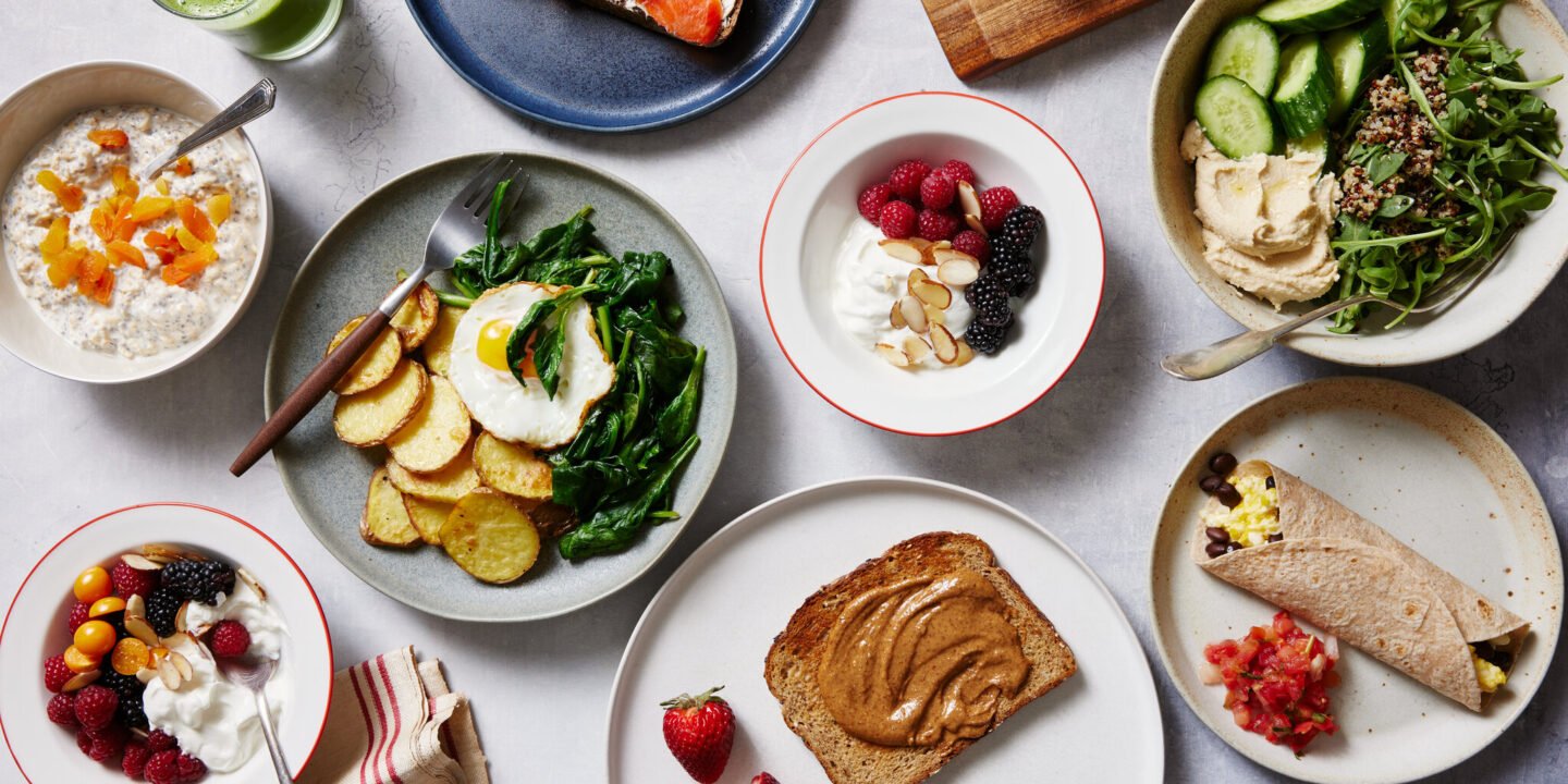 Healthy daily breakfast recipes including overnight oats, avocado toast, Greek yogurt parfait, fruit smoothie bowl, and scrambled eggs on a breakfast table